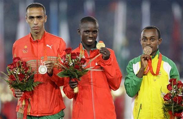 From left, silver medalist from Morocco Jaouad Gharib, Kenya's Samuel Kamau Wanjiru who won gold, and bronze medalist from Ethiopia, Tsegay Kebede, receive their medals for the men's marathon during the closing ceremonies.